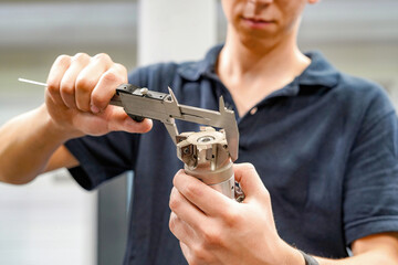 Measuring a cutting tool with a caliper for a CNC machine tool.