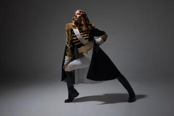 A glamorous blonde in a carnival uniform with epaulettes, posing with pretentious poses, a show...