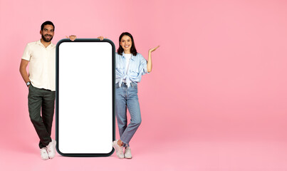 Positive cute beautiful couple posing with huge cell phone