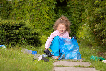 Girl collection plastic garbage in nature. kid picking up trash in park. Earth Day April 22. Save...