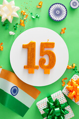 Celebration concept for India Independence Day. Top view vertical photo of indian flag, number 15 candle, patriotic presents, ashoka wheels, confetti on light green background