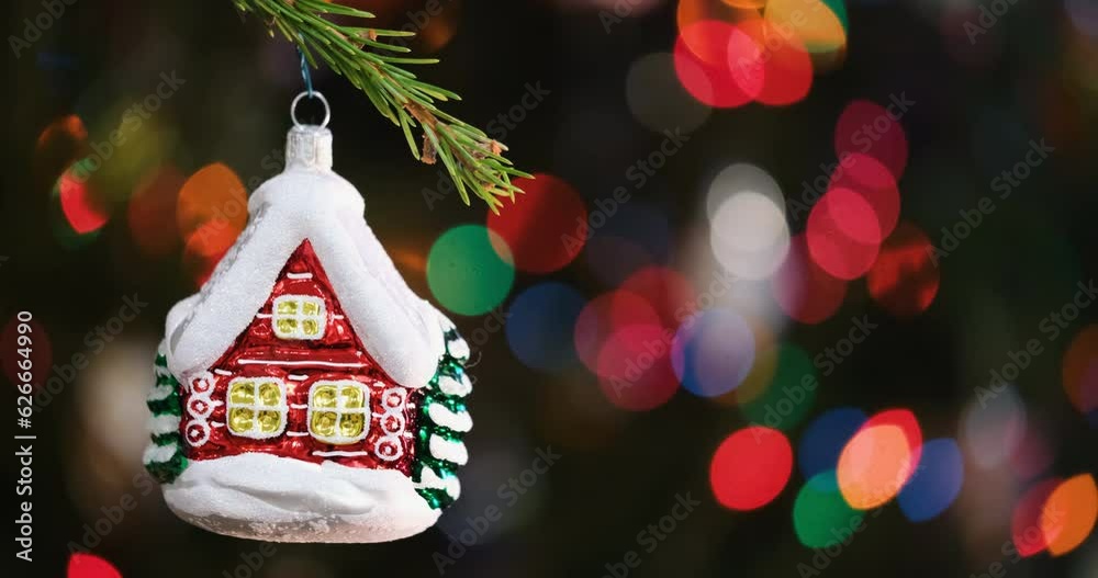 Aufkleber christmas tree decorated red toy house, fir branch with red toy house and festive lights on the chri
