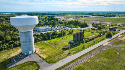 Nondescript white water tower in farmland green fields, train tracks, abandoned silo rural - obrazy, fototapety, plakaty