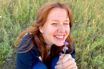 happy girl in the field in summer at sunrise or sunset, enjoying nature