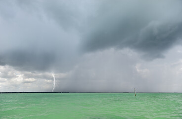 Squall with lightning strike approaching over water