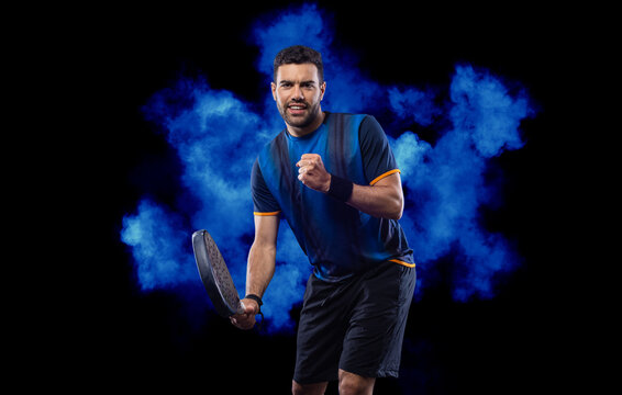 Happy padel tennis player with racket. Man athlete with paddle racket on court with neon colors. Sport concept. Download a high quality photo for the design of a sports app or betting site.