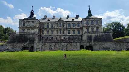 Fototapeta premium Pidgirtsі-young woman on the balcony of an old castle. Old castle near Lvov. Podgoretsky castle. Castles of Ukraine