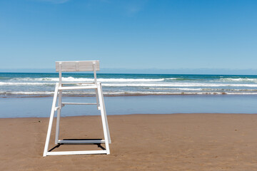 Elevated lifeguard chair on an empty beach shore.