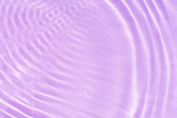 Obraz premium Purple water with ripples on the surface. Defocus blurred transparent pink colored clear calm water surface texture with splashes and bubbles. Water waves with shining pattern texture background.