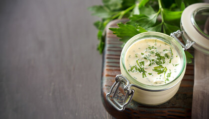 Homemade ranch dressing in a small jar with herbs