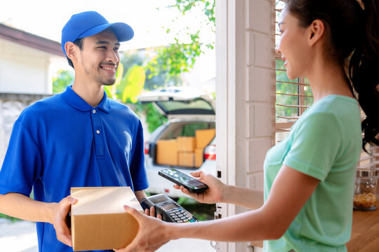 Delivery worker handing goods to female customer at doorstep, Fast and prompt delivery service.