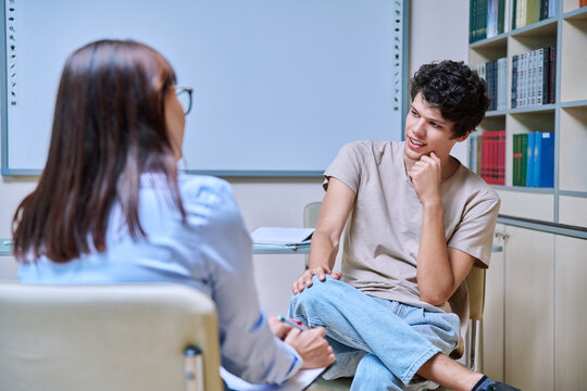 Young guy student at meeting with psychologist, college counselor in office