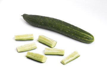 Whole and cut pieces of cucumber on white.