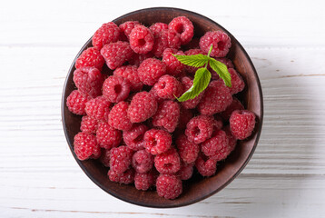Raspberry in a basket .on wooden background