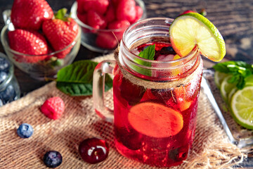 Ice berry cocktail. Raspberry, lime, strawberry, blueberry and mint leaves. Berry mojito in a misted glass.