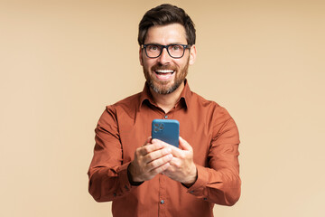 Portrait overjoyed latin man of handsome holding mobile phone shopping online isolated on...