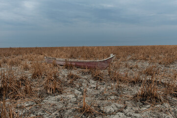 A traditional marsh boat abanodoned on dry marshland during a drought in the marshes of Southern...