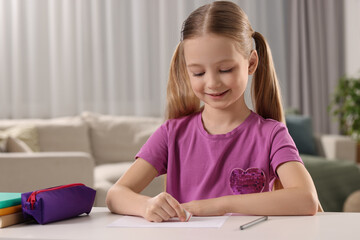 Naklejka premium Girl using eraser at white desk in room