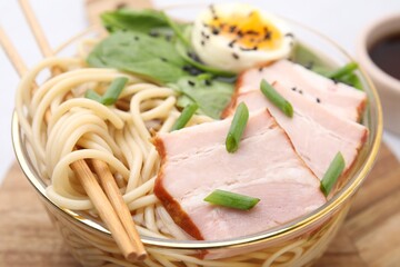 Delicious ramen with meat on table, closeup. Noodle soup