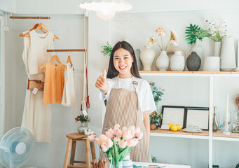 Small business owners pose smiling in their small shop to welcome customers and get customers online. And check the orders that customers have ordered of online retailers - online shopping.