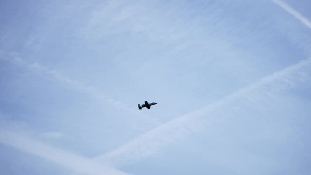 A-10 Thunderbolt II fighter plane in a very fast pass, with condensation trails at the wing edges and root, slow motion