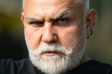 Close up portrait of serious expression 60 year old elder senior man. Mature man with serious expression on face.