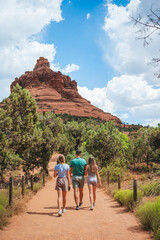 Family of father and kids enjoy the view of the Sedona landscape from the top of the Bell Rock hiking trail, famous for its many energy vortexes and red rocks.