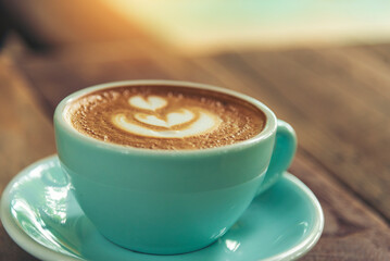 Latte art coffee cup with milk on wooden table. Espresso shot make latte art hot coffee cup. Cappuccino with milk in italian coffee shop cafe. Brown hot caffeine beverage in cafeteria with copy space
