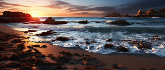 Dramatic sunset over serene rocky beach, waves crashing, golden reflections on wet sand, tranquil seascape.