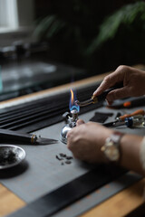 Man doing leatherwork, in a leather working workshop, making a black leather belt
