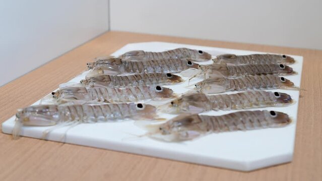 Raw mantis shrimps appear on the kitchen cutting board