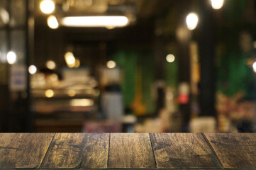 Empty dark wooden table in front of abstract blurred boken bankground of restaurant. Can used for display or montage your products. Mock up for space.