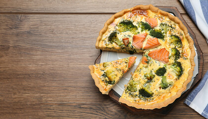 Piece of delicious homemade quiche with salmon and broccoli on wooden table, top view. Space for text