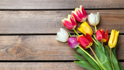 Beautiful colorful tulips on wooden table, top view. Space for text