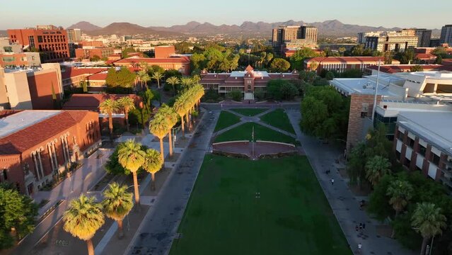 Old Main at University of Arizona. Aerial dolly forward towards iconic collegiate building. Beautiful college campus with buildings in Tucson, AZ.