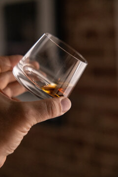 Man holding a glass of Scotch, doing a Whisky tasting