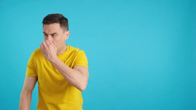 Man sniffs bad smell and gesticulates with hand