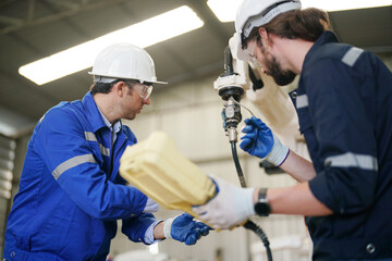 Multiracial industrial engineers working at automated AI robotic production factory, New industrial technology concept.