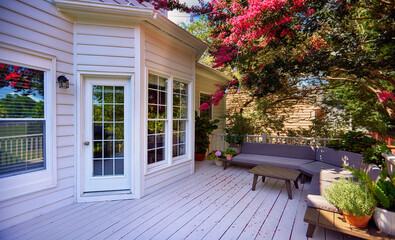 beautiful wooden terrace under the blooming crape myrtle. lounge zone in the summer garden - 626726749
