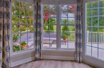 large windows with the view on summer garden with lounge zone