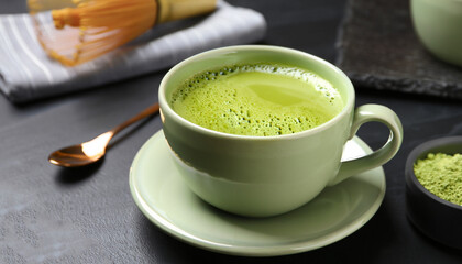 Cup of fresh matcha tea on black table, closeup