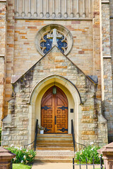 Fototapeta na wymiar Front entrance to St. Pauls Episcopal Church with heavy oak doors and cross and stained glass