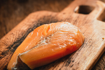 Raw salmon steak on wooden chopping board