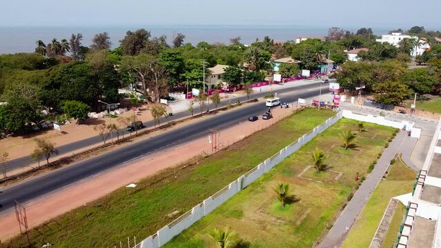 Establishing drone pan above Banjul city roadway and arch 22 The Gambia West Africa