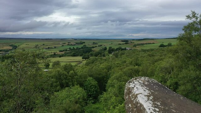 Aerial flight starting behind the Druid's writing desk at Brimham rocks in North Yorkshire and flying up looking out to the landscape