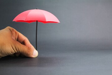 small red umbrella with a dark background. insurance coverage concept