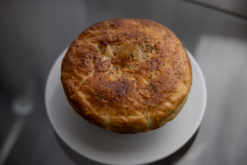 Home made chicken pot pie on a glass table next to a window at sunset