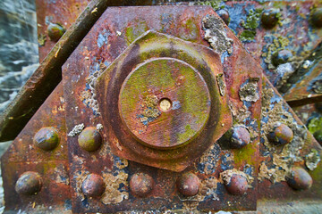 Background asset industry rusty metal bolt with peeling corroded rivets with oil spill colors