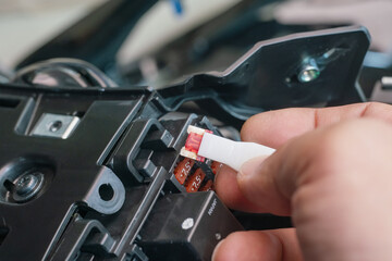 Mechanic replaces a fuse battery of motorcycle at garage. .motorcycle maintenance and service and...