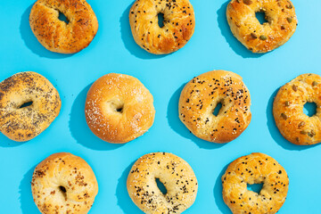 Repeating pattern of bagels on a blue background.